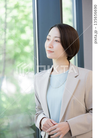 窓際で考えるビジネスマンの女性 キャリアに悩む転職どうしようかな 窓際で考えるビジネスマンの女性 キャリアに悩む転職どうしようかな 135656690