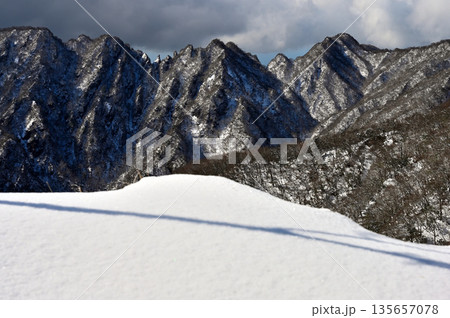 愛鷹山塊の越前岳　北白ガレンの雪庇の先に聳える厳冬の鋸岳の稜線 135657078