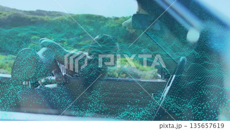 Sunglassed Indian woman leaning through lowered door on road, with point-cloud overlay, copy space 135657619