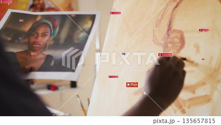 Painting artist applying tones on canvas in studio with printed reference and brush, copy space 135657815