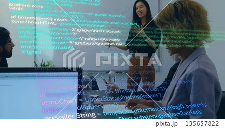 Presenting mid adult Indian woman demonstrating code in meeting room, with laptops and projector 135657822