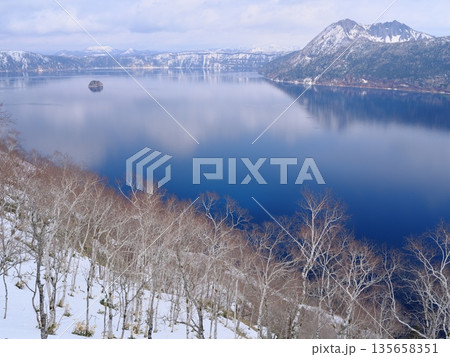 残雪の摩周湖第1展望台からダケカンバ越しに摩周湖のカムイシュ島を望む 残雪の摩周湖第1展望台からダケカンバ越しに摩周湖のカムイシュ島を望む 135658351