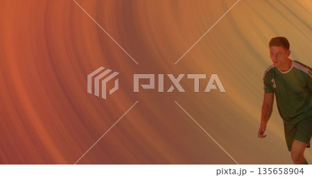 Jogging athlete wearing green sports uniform and shoes in studio with orange backdrop, copy space Jogging athlete wearing green sports uniform and shoes in studio with orange backdrop, copy space 135658904
