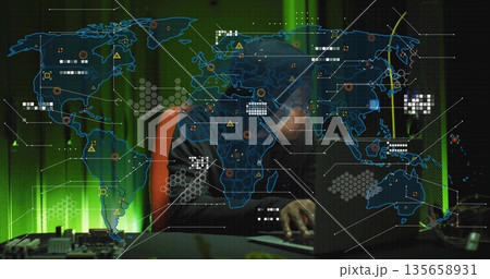 Monitoring security analyst wearing hoodie studying network map in dim control room, with laptop Monitoring security analyst wearing hoodie studying network map in dim control room, with laptop 135658931