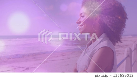Gazing woman leaning against railing on beachside walkway, with beach and lens flare, copy space Gazing woman leaning against railing on beachside walkway, with beach and lens flare, copy space 135659012