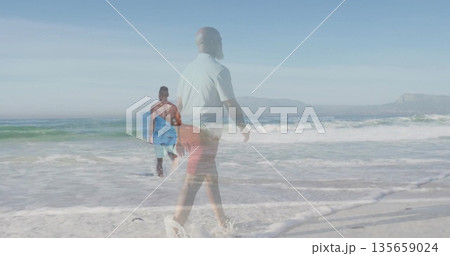 Walking two men wearing casual beach clothing along beach, carrying blue surfboard with foamy waves Walking two men wearing casual beach clothing along beach, carrying blue surfboard with foamy waves 135659024