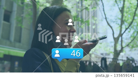 Chatting woman using smartphone on urban sidewalk, with user icons and notification bubble Chatting woman using smartphone on urban sidewalk, with user icons and notification bubble 135659141