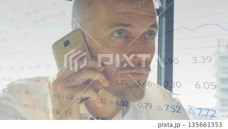 Holding gold smartphone, executive in white shirt watching market data by office window Holding gold smartphone, executive in white shirt watching market data by office window 135661353