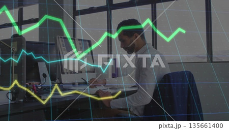 Man wearing dress shirt writing in notebook using dual monitors at office desk, copy space 135661400