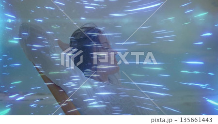 Leaning back adult male folding arms on wooden lounge chair at beach, bluish green light streaks 135661443
