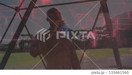 Drinking water shirtless man under metal pavilion at field, with blue bottle, white picket fence Drinking water shirtless man under metal pavilion at field, with blue bottle, white picket fence 135661560