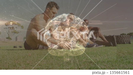 Holding rigid plank positions three men in shorts on grassy field, with tractor tires 135661561