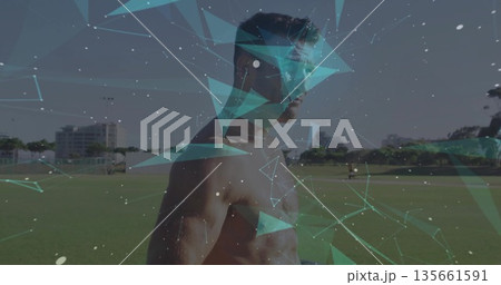 Standing shirtless male athlete gazing to right at grass sports field, with polygon overlay network Standing shirtless male athlete gazing to right at grass sports field, with polygon overlay network 135661591