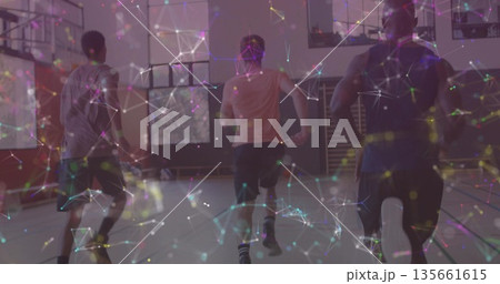 Sprinting trio teammates running down basketball court in gymnasium, showing network overlay 135661615