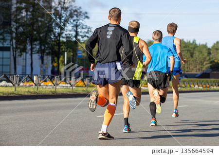Four male athletes running marathon 135664594