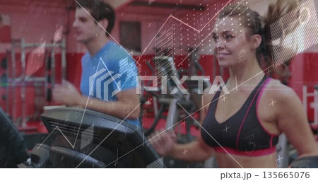 Running woman in sportswear on treadmill at gym, with digital console and weight racks, copy space 135665076