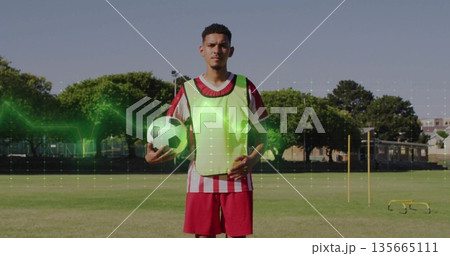 Soccer player holding ball in sports field, with fluorescent vest slalom poles hurdles and waveform 135665111