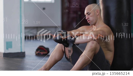 Adjusting male boxer tightening gloves in boxing gym, with heavy bag and data overlay, copy space Adjusting male boxer tightening gloves in boxing gym, with heavy bag and data overlay, copy space 135665214