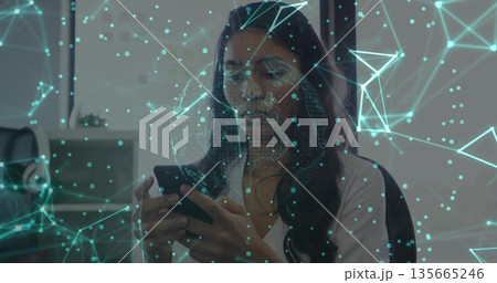 Tapping smartphone, office worker in white shirt displaying digital network overlay at office desk Tapping smartphone, office worker in white shirt displaying digital network overlay at office desk 135665246
