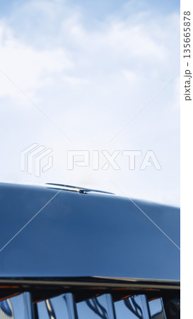 Shiny vehicle hood reflects sky and surroundings on a sunny day Shiny vehicle hood reflects sky and surroundings on a sunny day 135665878