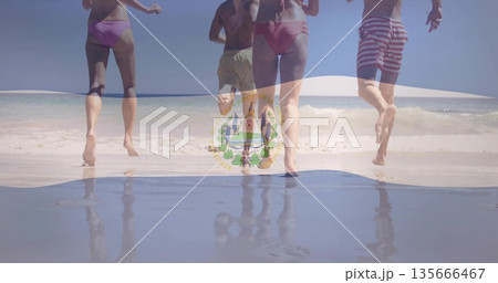 Sprinting four friends in swimsuits and board shorts on sandy shoreline, splashing ocean water Sprinting four friends in swimsuits and board shorts on sandy shoreline, splashing ocean water 135666467