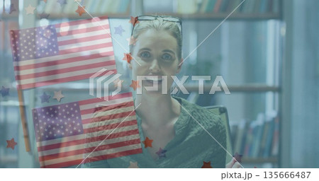 Hosting mid adult woman in green blouse livestreaming at desk, with US flag and star overlays Hosting mid adult woman in green blouse livestreaming at desk, with US flag and star overlays 135666487