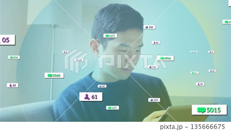 Reviewing tablet Asian man sitting on sofa under floor lamp in living room, with digital overlays Reviewing tablet Asian man sitting on sofa under floor lamp in living room, with digital overlays 135666675