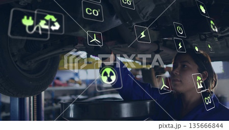 Female mechanic in jumpsuit draining oil, inspecting car underside in garage, with lift, eco icons Female mechanic in jumpsuit draining oil, inspecting car underside in garage, with lift, eco icons 135666844