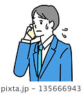スマホで会話中に困っているスーツ姿の若い男性のイラスト 135666943