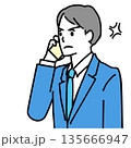 怒った表情で電話するスーツ姿の若い男性のイラスト 135666947