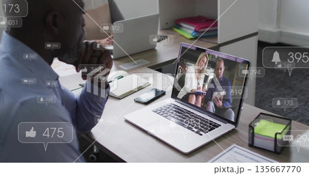 Leaning African American man focusing on laptop at office desk with notification icons, copy space Leaning African American man focusing on laptop at office desk with notification icons, copy space 135667770