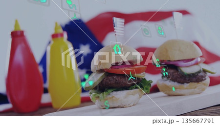 Two mini hamburgers resting on wooden board in studio, with flag backdrop ketchup mustard eco icons 135667791