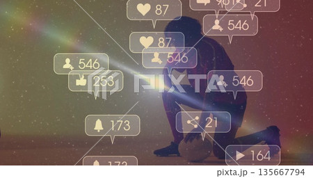 Shining smartphone beam kneeling athlete in sportswear lighting digital sky with icons, soccer ball Shining smartphone beam kneeling athlete in sportswear lighting digital sky with icons, soccer ball 135667794