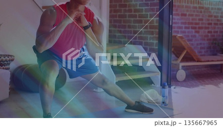 Athlete performing side lunge in home gym, with foam roller water bottle towel watch lounge chair 135667965