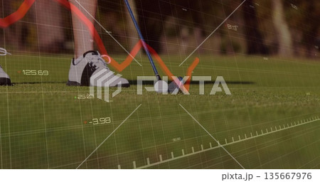 Poising club head behind golf ball on golf course turf, showing numeric data overlay and chart 135667976