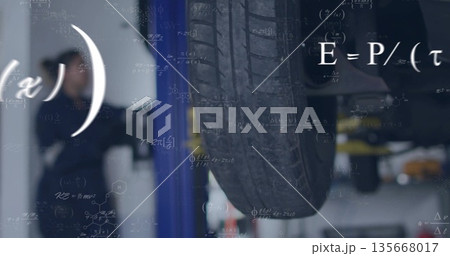 Showing car tire wheel assembly revealing undercarriage in workshop with hydraulic lift and tools 135668017