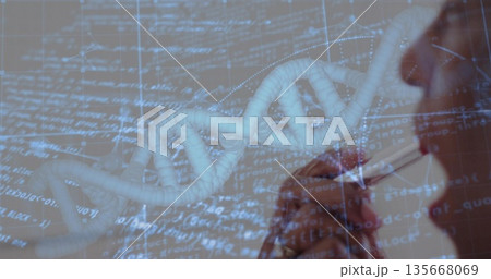 Displaying 3D DNA helix model over abstract code grid, with researcher holding pen to chin 135668069