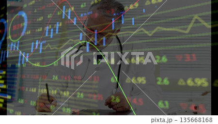 Writing doctor wearing lab coat and stethoscope filling notes in office, with stock chart overlays Writing doctor wearing lab coat and stethoscope filling notes in office, with stock chart overlays 135668168