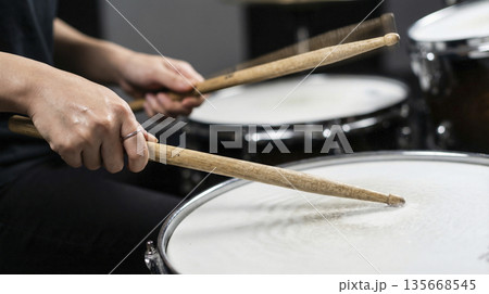 スタジオでスネアドラムを叩くドラマーの手元とスティックのクローズアップ 135668545