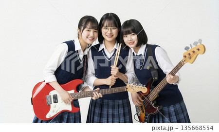 楽器を持って寄り添い笑顔を見せる仲の良い可愛い日本人女子高生バンド 135668554