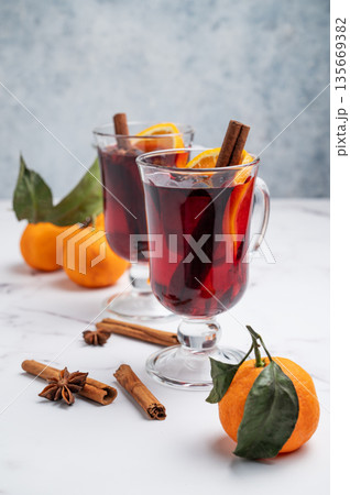 Two glasses of mulled wine, orange, cinnamon, and star anise on a marble background with spice 135669382
