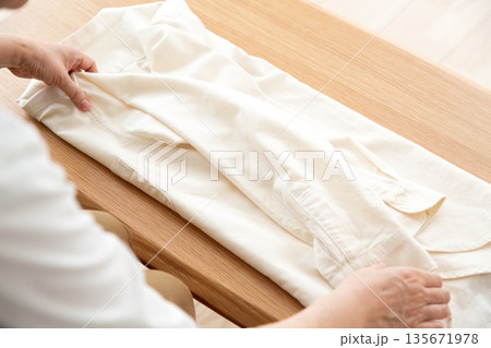 白いシャツを畳む女性の手元 白いシャツを畳む女性の手元 135671978
