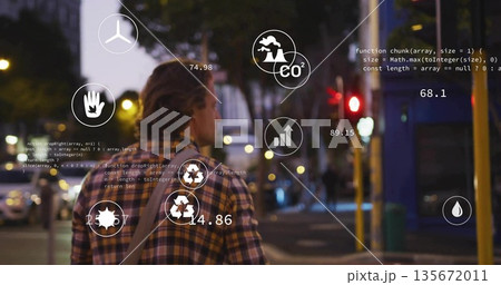 Walking man in plaid shirt carrying shoulder bag down street at dusk, showing eco icons overlay 135672011