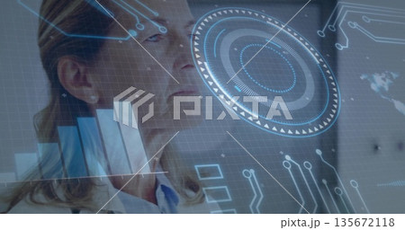 Standing senior woman analyzing holographic bar charts on digital interface in lab, with world map 135672118