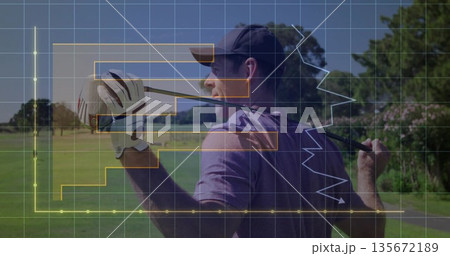 Man wearing cap and golf glove holding driver club behind shoulder on fairway, showing grid charts 135672189