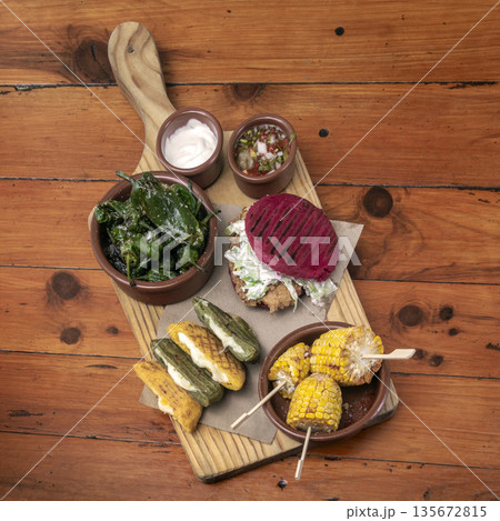 mixed colombian and venezuelan snack food platter on wooden restaurant table 135672815