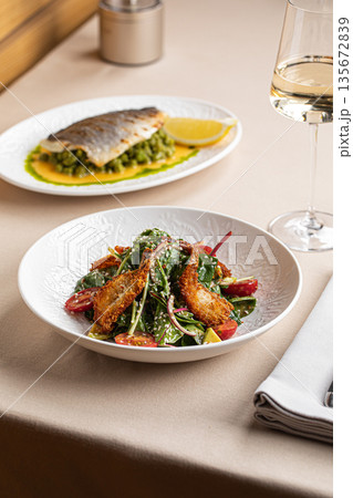 Crispy shrimp salad served with white wine 135672839