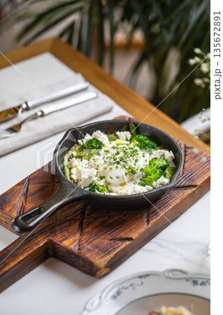 Skillet eggs with broccoli feta and herbs 135672891