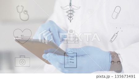 Tapping doctor wearing lab coat and gloves in hospital with digital tablet, floating medical icons Tapping doctor wearing lab coat and gloves in hospital with digital tablet, floating medical icons 135673491