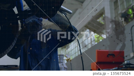 Grinding sparks flying as blue coverall mechanic welding undercarriage at workshop, with toolbox Grinding sparks flying as blue coverall mechanic welding undercarriage at workshop, with toolbox 135673524